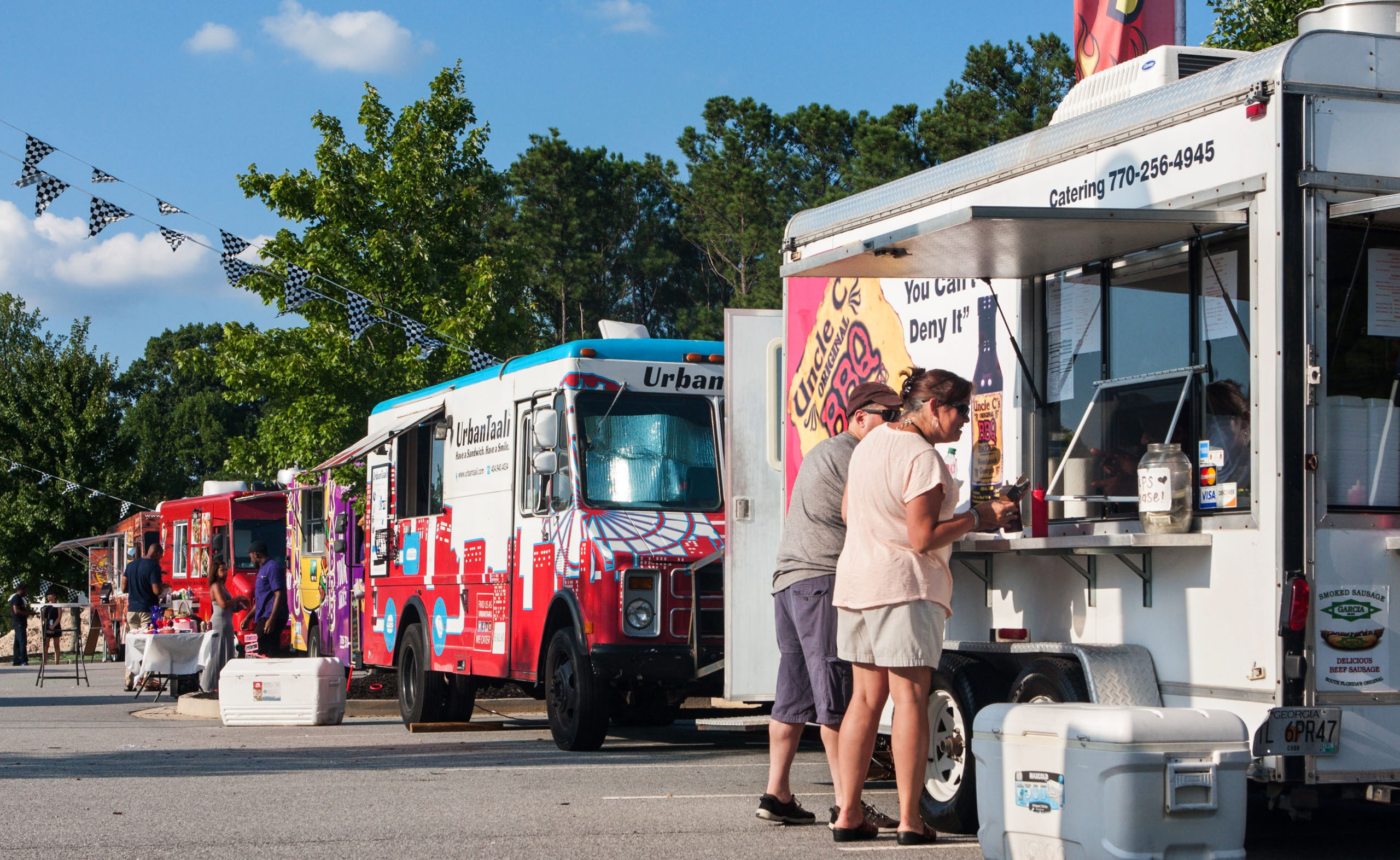 row of colorful food trucks serving customers