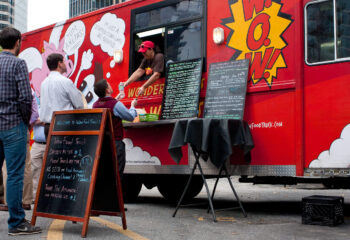 red food truck owner serving a group of customers