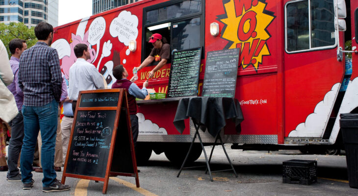 red food truck owner serving a group of customers