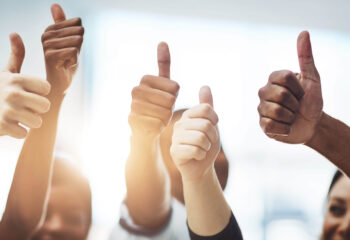 diverse group of people doing thumbs up indicating success