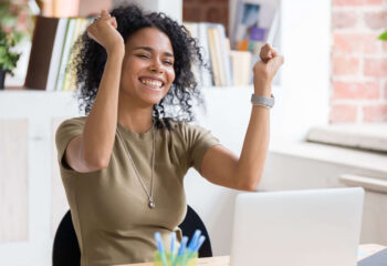 motivated woman smiling with both fists raised