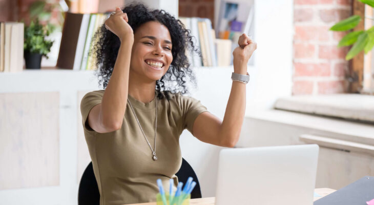 motivated woman smiling with both fists raised