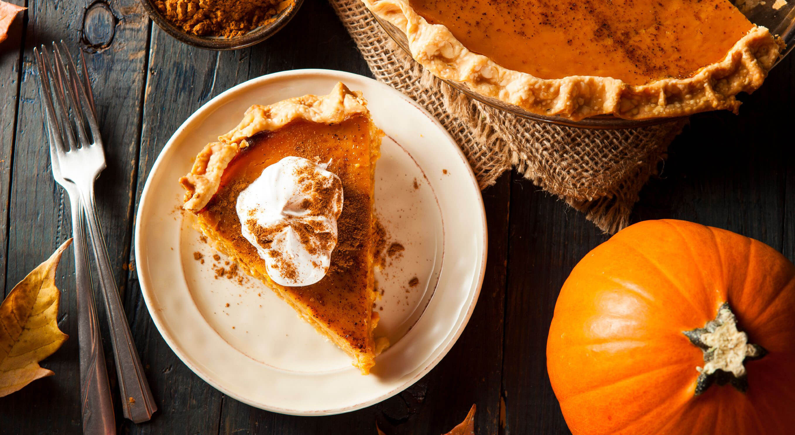 pumpkin pie on a plate on a dark wooden table