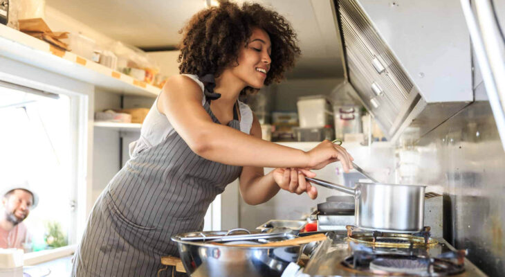 woman preparing food in a food truck kitchen