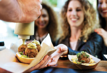 person preparing food in front of customers