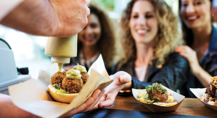 person preparing food in front of customers