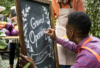food truck owner designing a grand opening sign on a chalkboard