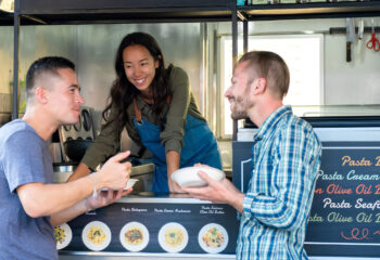 three people in a food truck talking to each other