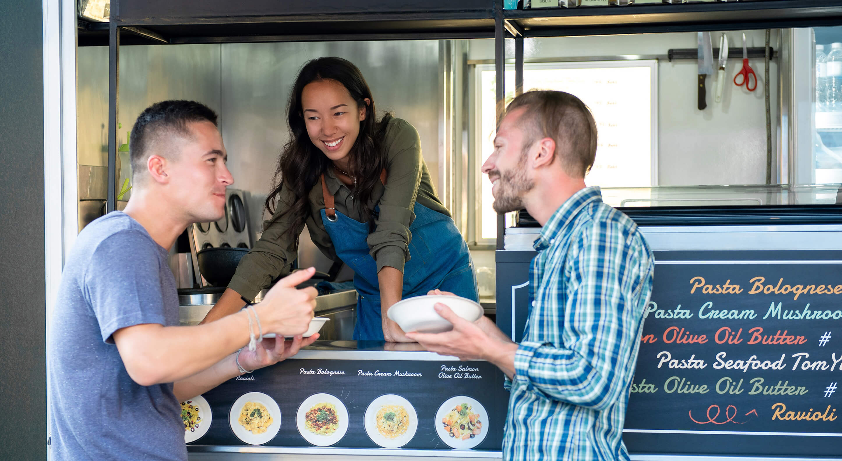 three people in a food truck talking to each other