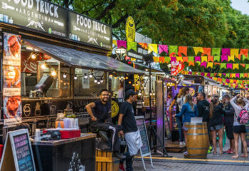 food trucks lined up in a food truck fair filled with customers