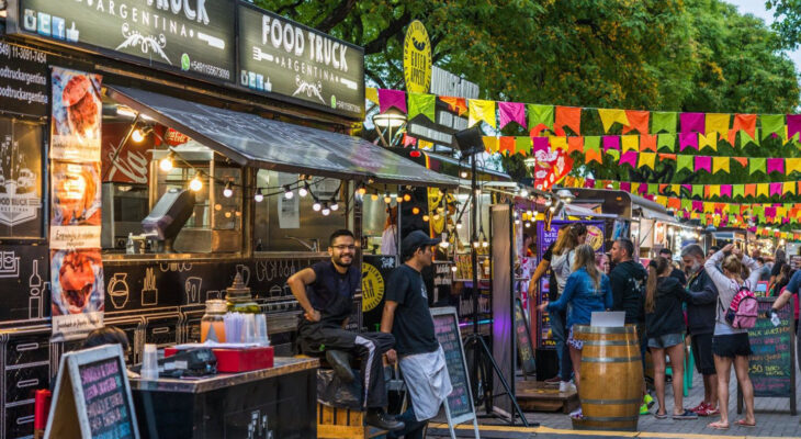 food trucks lined up in a food truck fair filled with customers