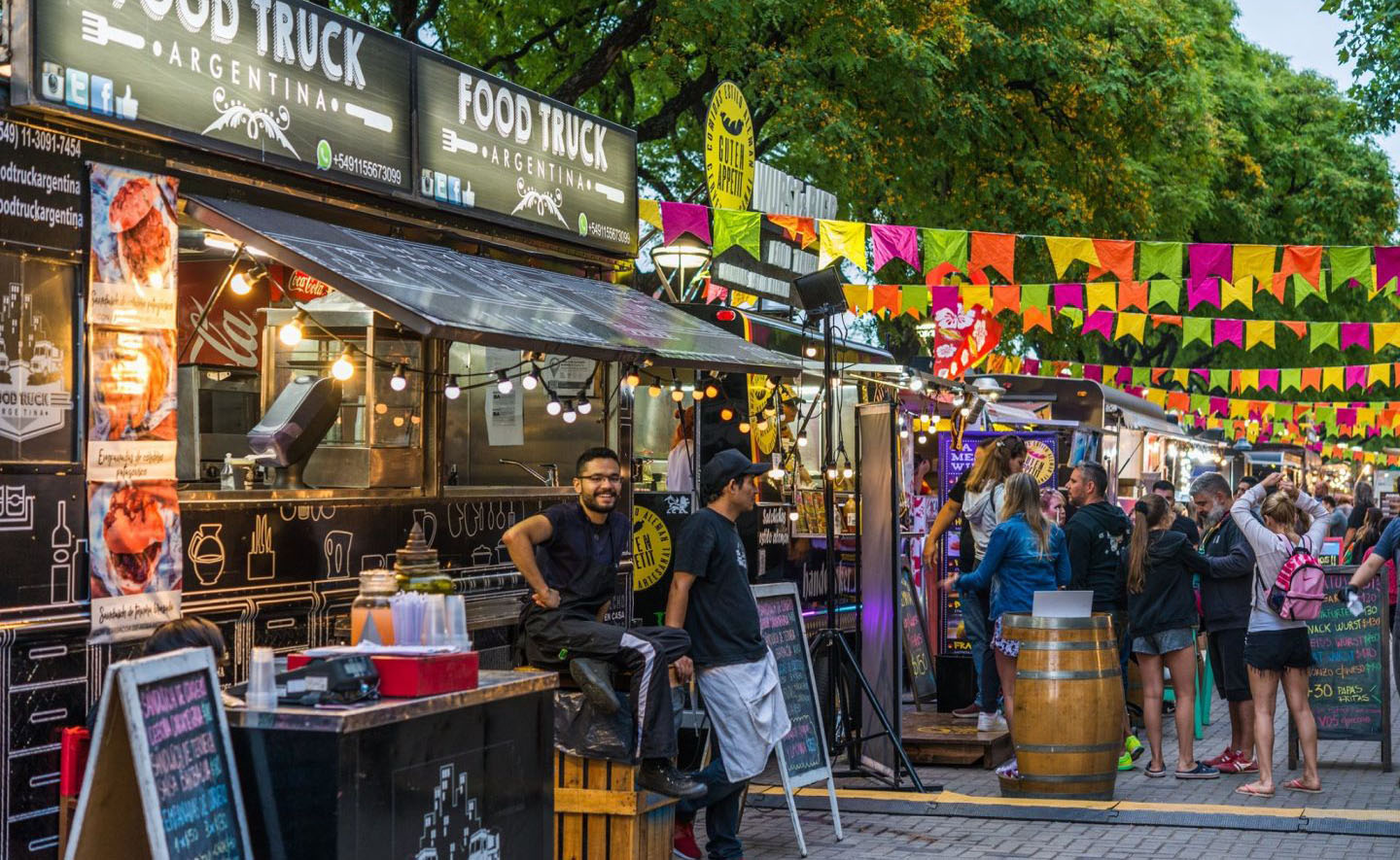 food trucks lined up in a food truck fair filled with customers