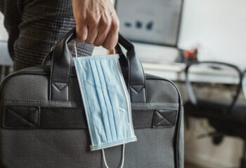 person carrying a briefcase and a face mask during covid-19 pandemic