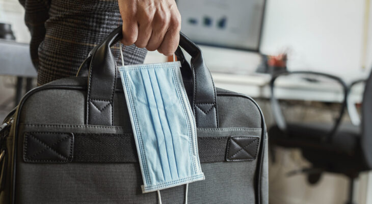 person carrying a briefcase and a face mask during covid-19 pandemic