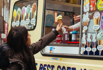 ice cream truck owner handing ice cream to a customer