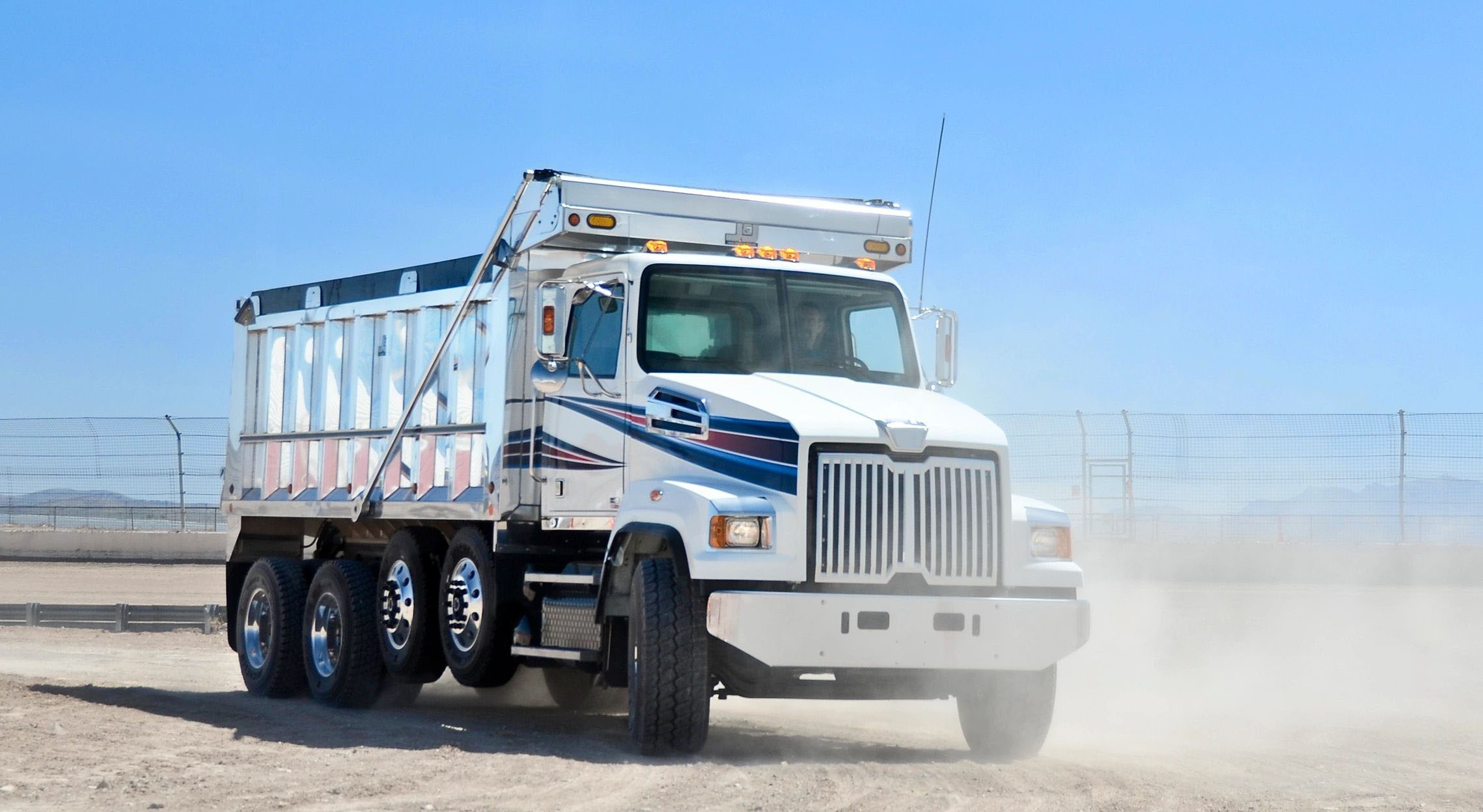 white dump truck on a dusty road