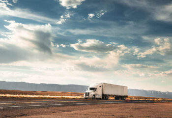 lone white long-haul truck on a deserted road