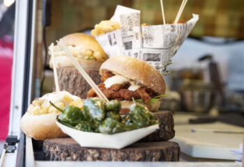 sandwich and sides presented on a wooden plate