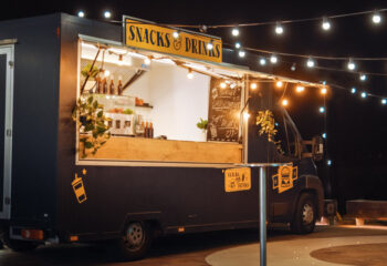 dark gray food truck selling snacks and drinks in the evening