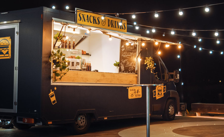 dark gray food truck selling snacks and drinks in the evening
