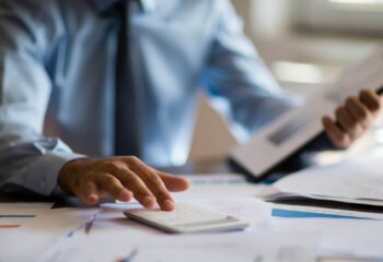 businessman calculating taxes on a calculator