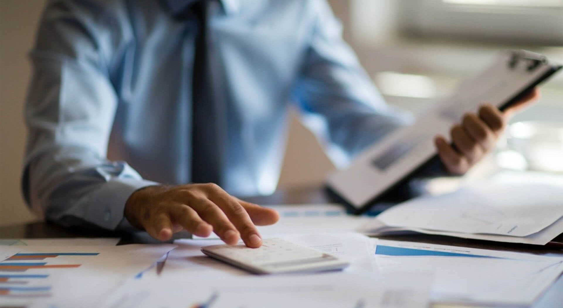 businessman calculating taxes on a calculator