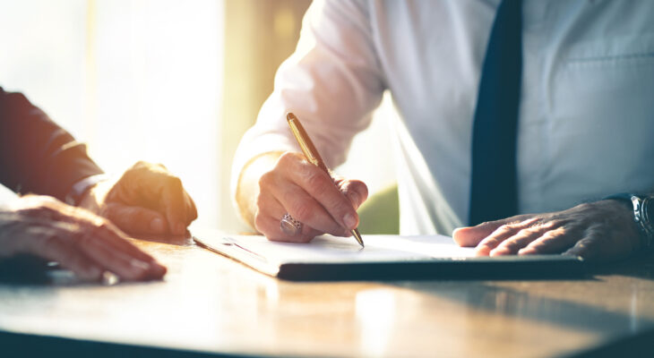 two businessmen signing a document for a food truck license