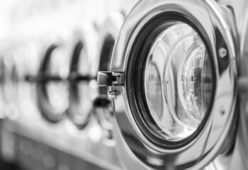 a row of front load stainless steel washing machines