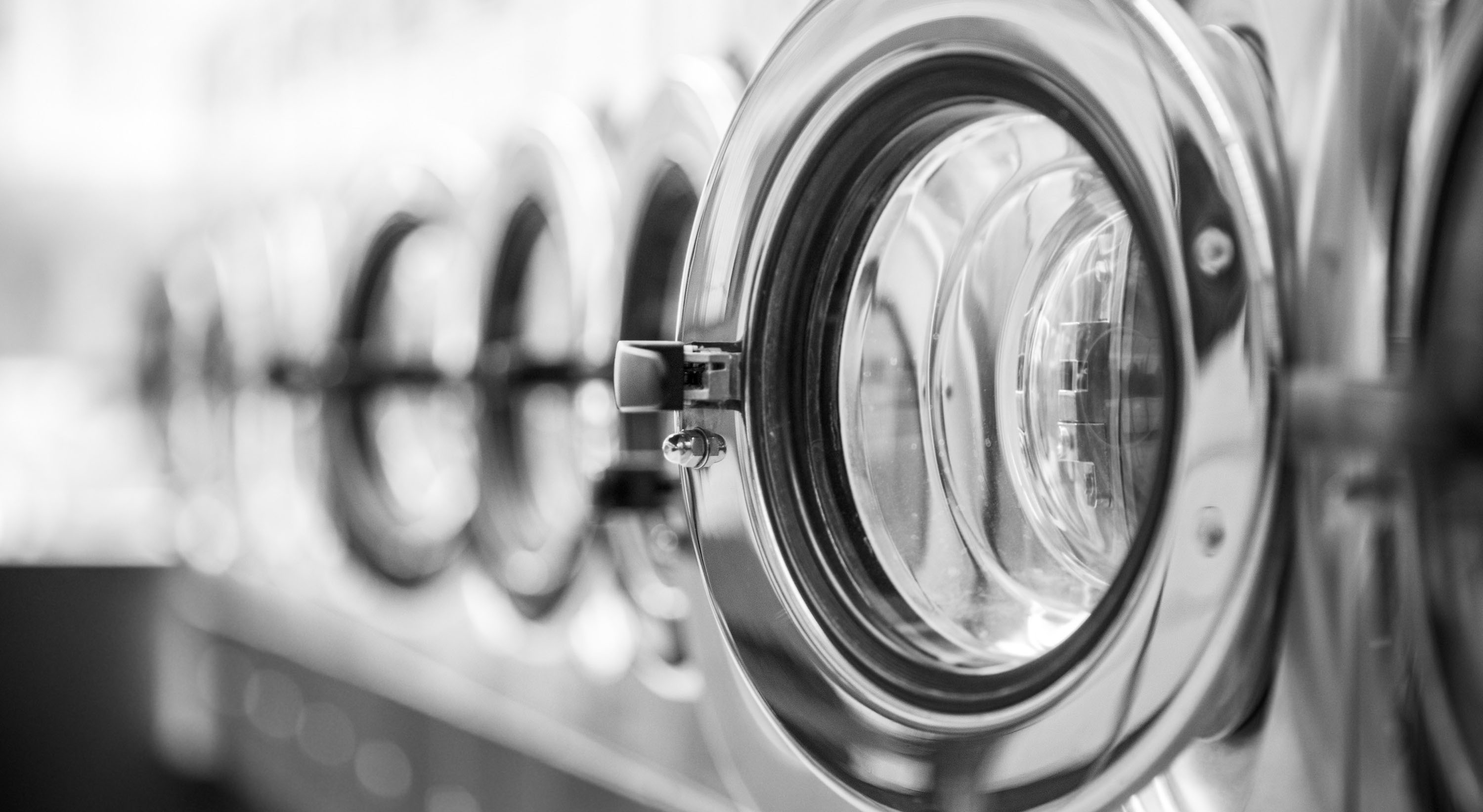 a row of front load stainless steel washing machines