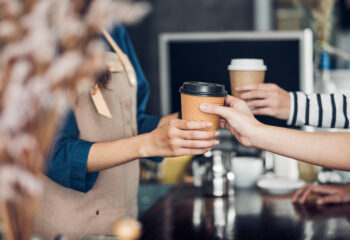 barista handing coffee to customers