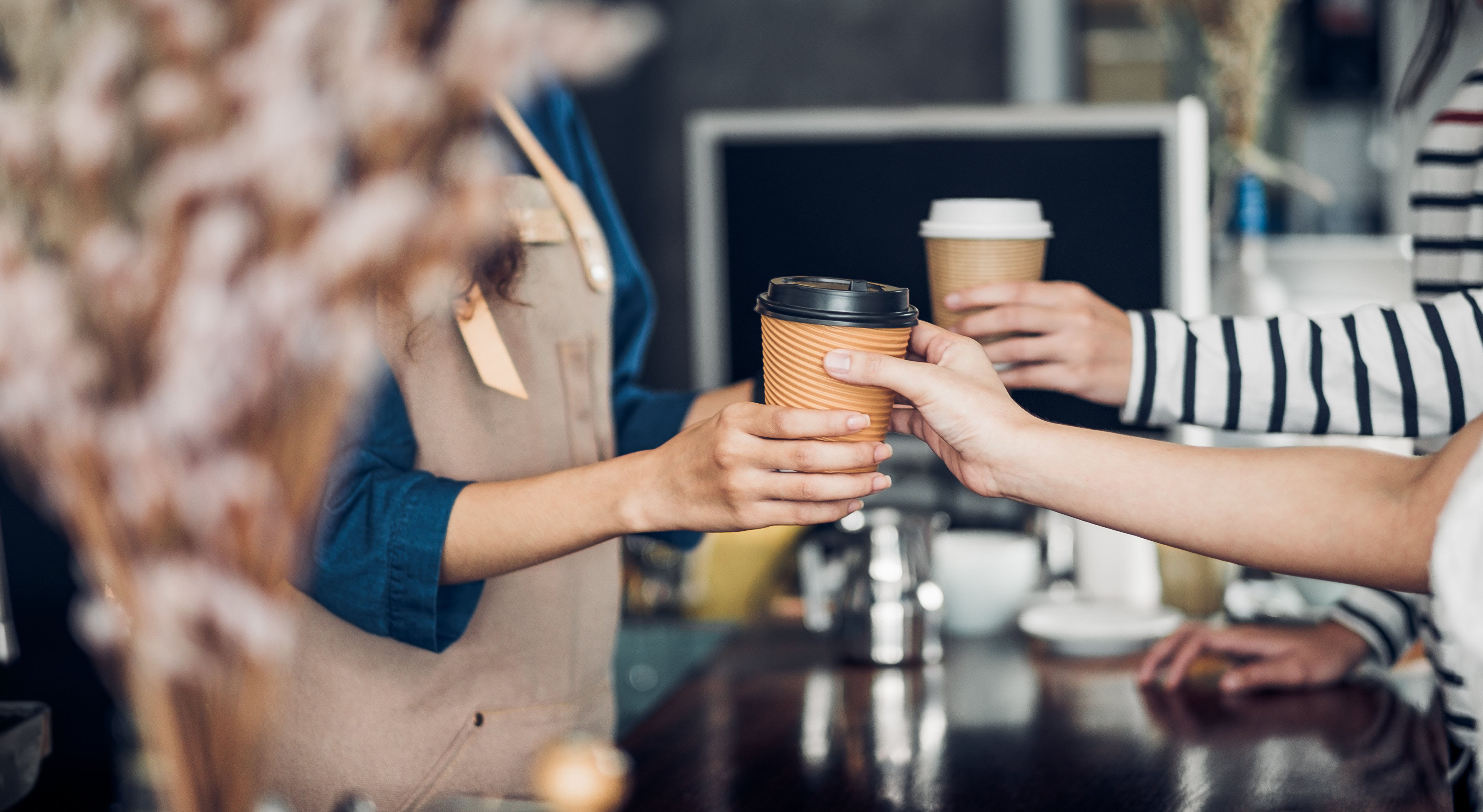 barista handing coffee to customers