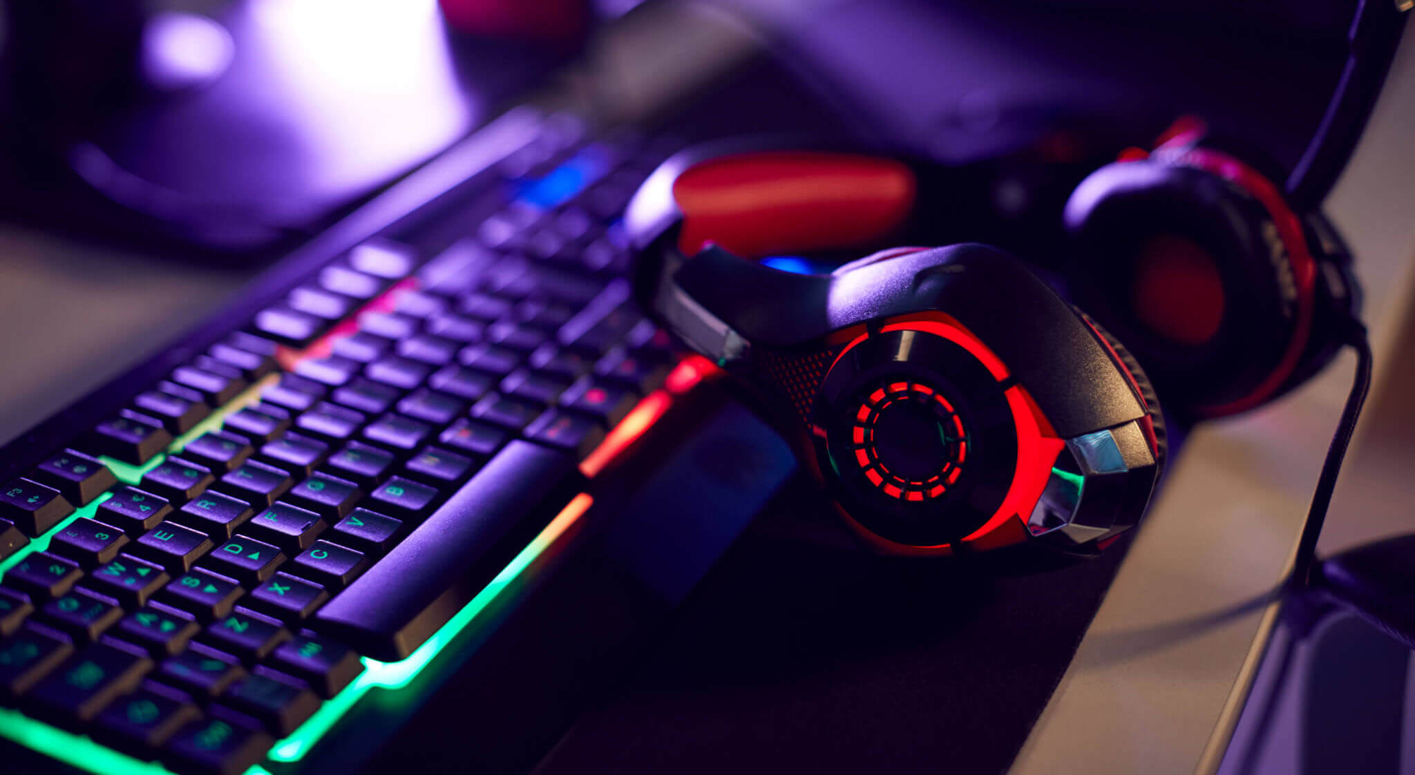 RGB gaming keyboard and headset on a desktop