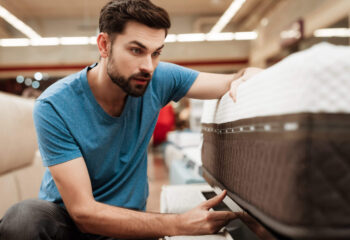 bearded man buying mattress at a store