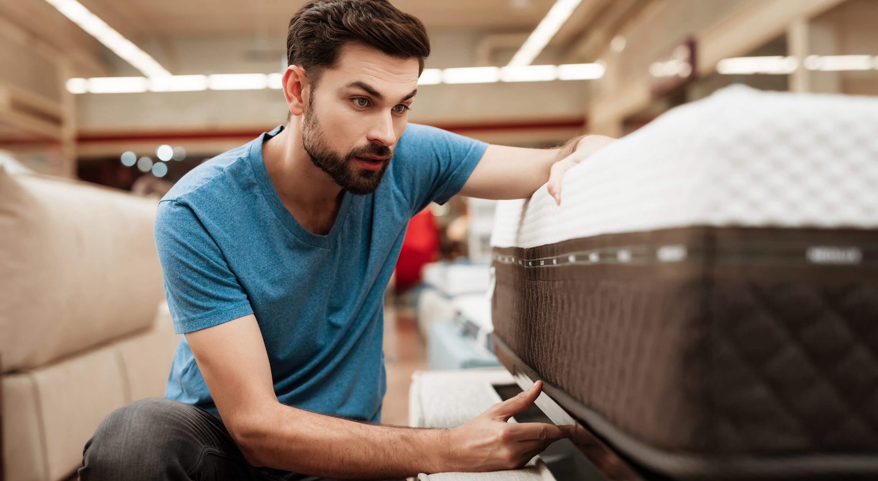 bearded man buying mattress at a store