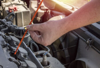 man holding dipstick to check transmission fluid