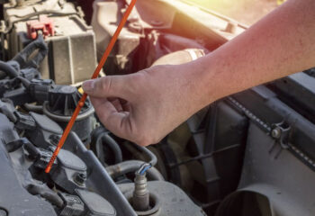 man holding dipstick to check transmission fluid