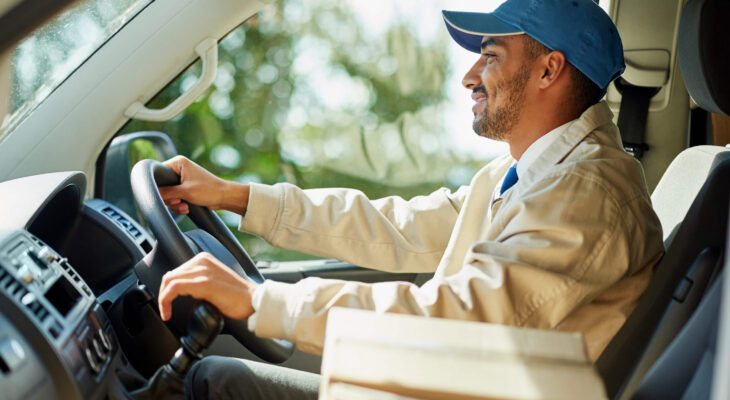 smiling delivery truck driver while holding gear stick