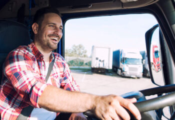 happy smiling truck driver in a semi truck