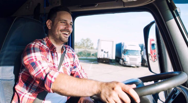 happy smiling truck driver in a semi truck