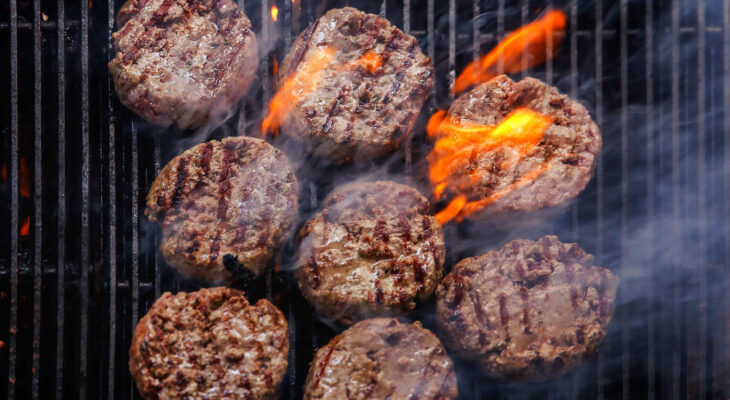 burger being cooked on a barbecue grill