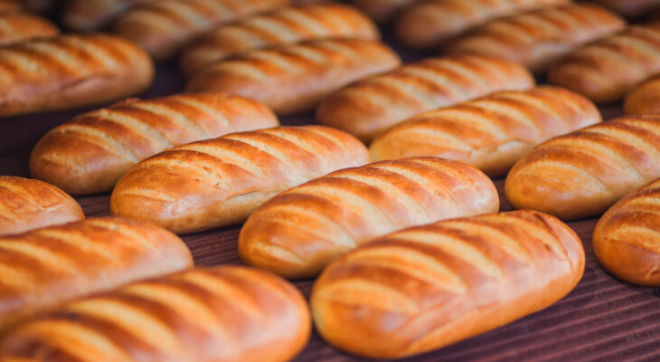 a bunch of bread lined up at a food tray