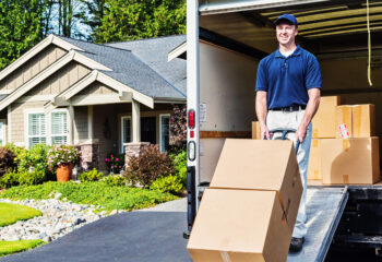 smiling person loading boxes into a moving truck