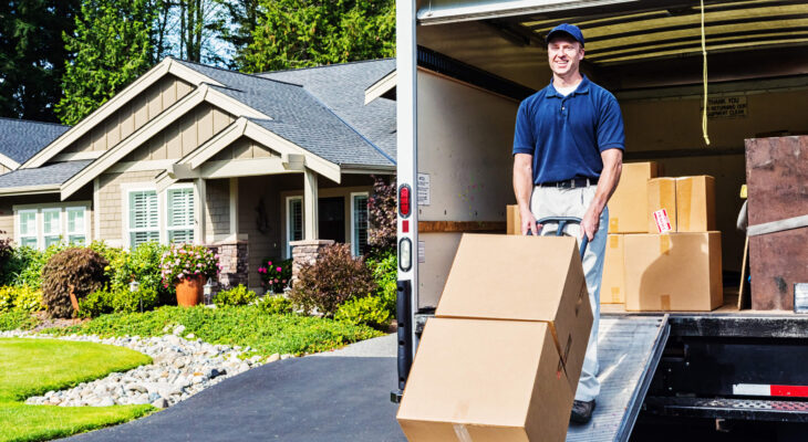 smiling person loading boxes into a moving truck