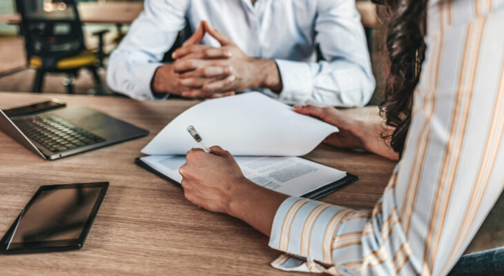 close up of a businesswoman signing a food truck insurance policy at an office table