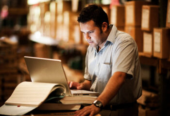 trucking business manager using a trucking load board at a warehouse