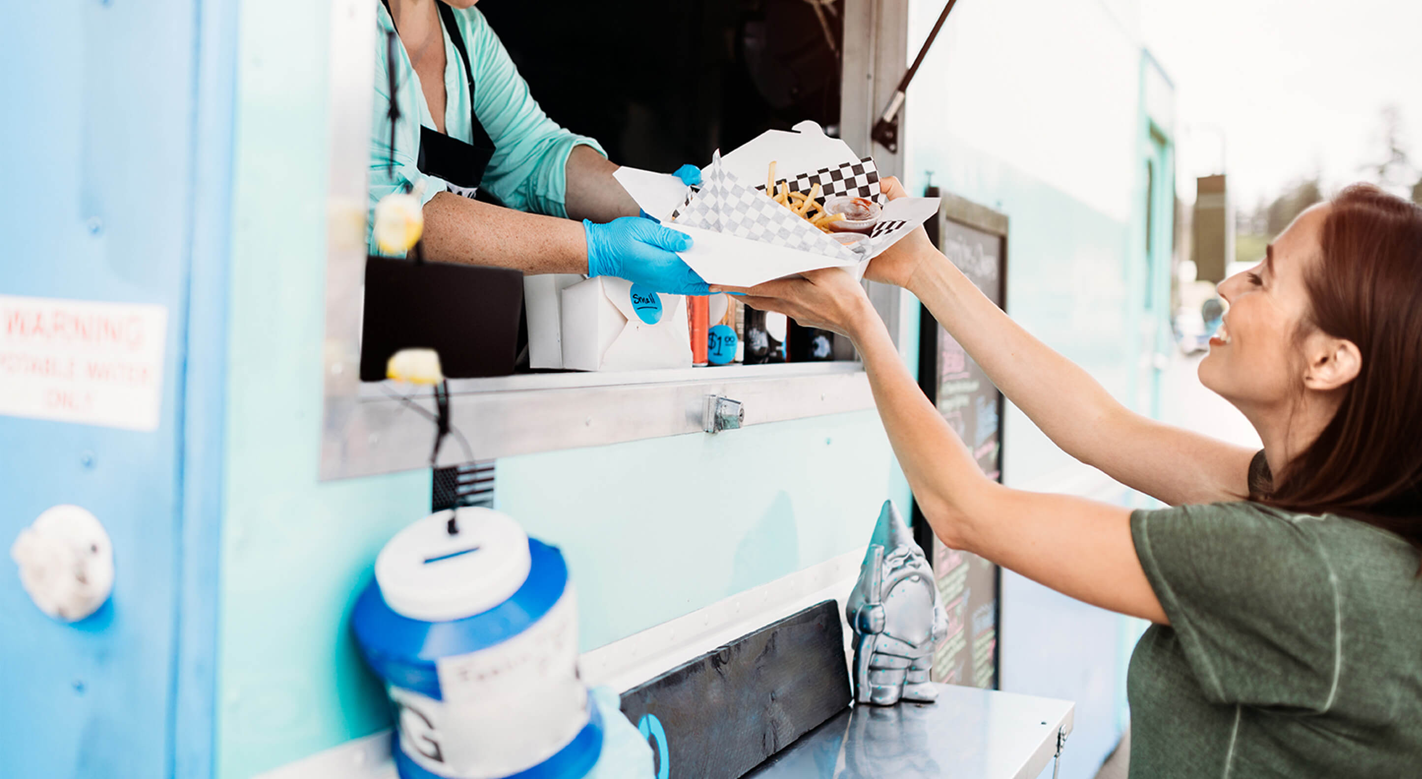 female customer receiving her order from a food truck owner