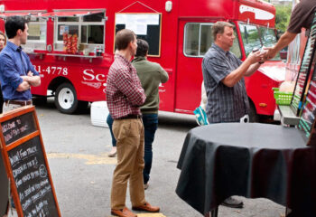 group of people lined up in front of a food truck