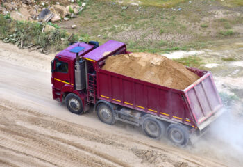 dump truck transports sand in an open pit mine
