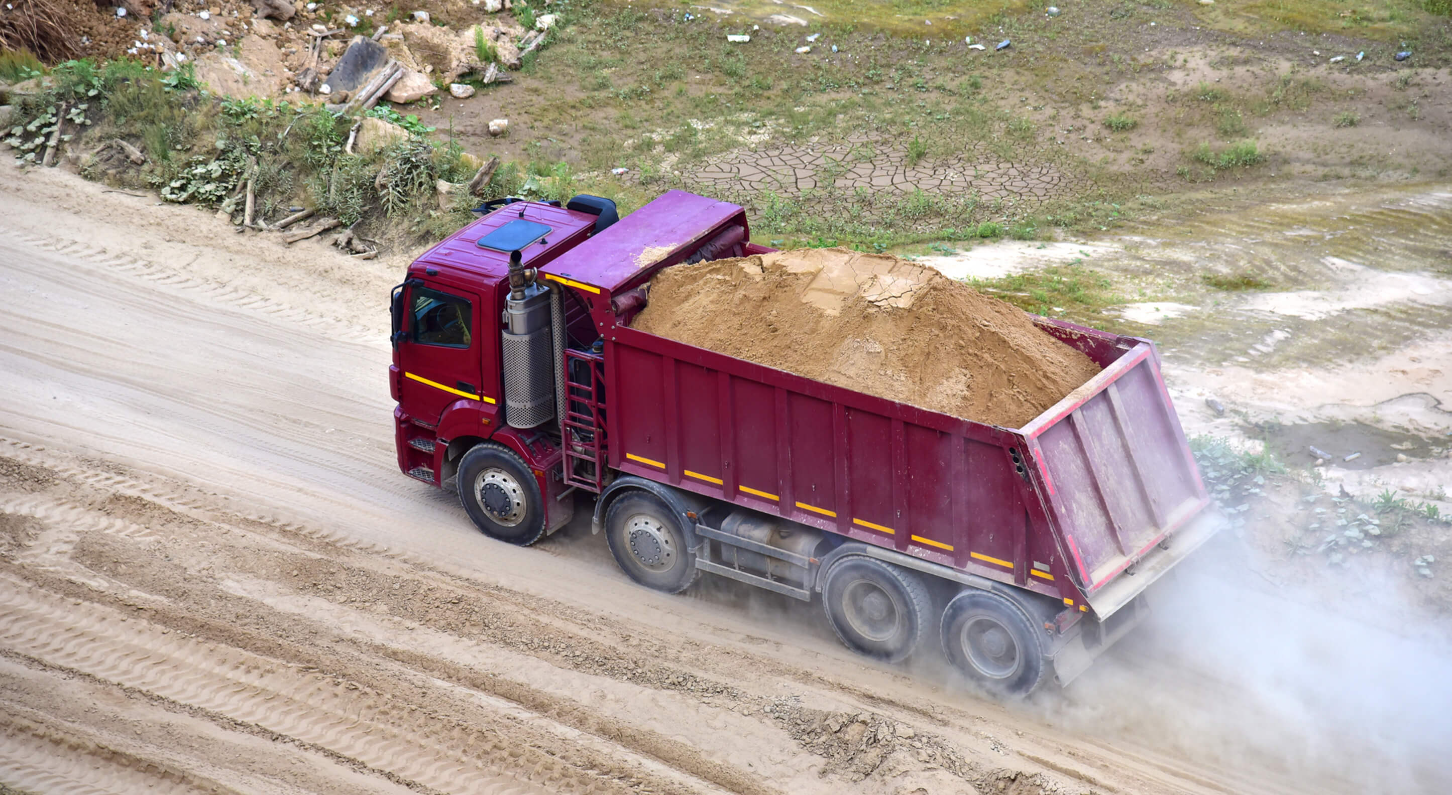 dump truck transports sand in an open pit mine