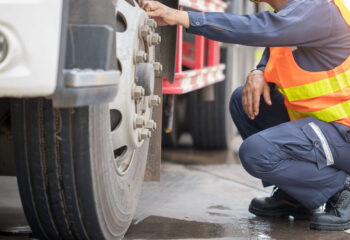 truck inspector checking a semi truck before transporting goods